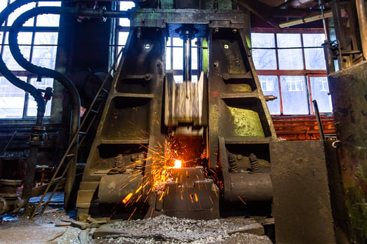 Forging hammer striking a hot object