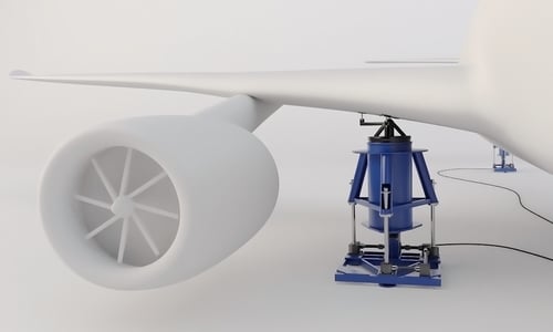A 3D rendering of Fabreeka PAL Isolator that has been designed as part of a Soft Support System for aircraft during testing. The large blue isolator is lifting up the wing of the airplane.