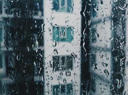 A window with water droplets facing outward to another structure.